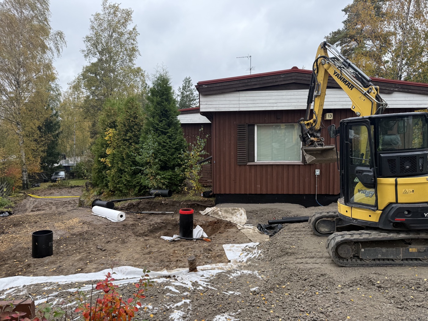 Maanvaihto ja patolevyjen vedeneristystyö rakennuksen vierellä