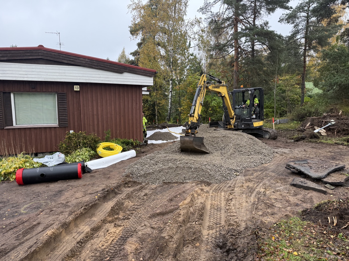 Kaivinkone rakentaa asfaltoitavan pihan pohjia