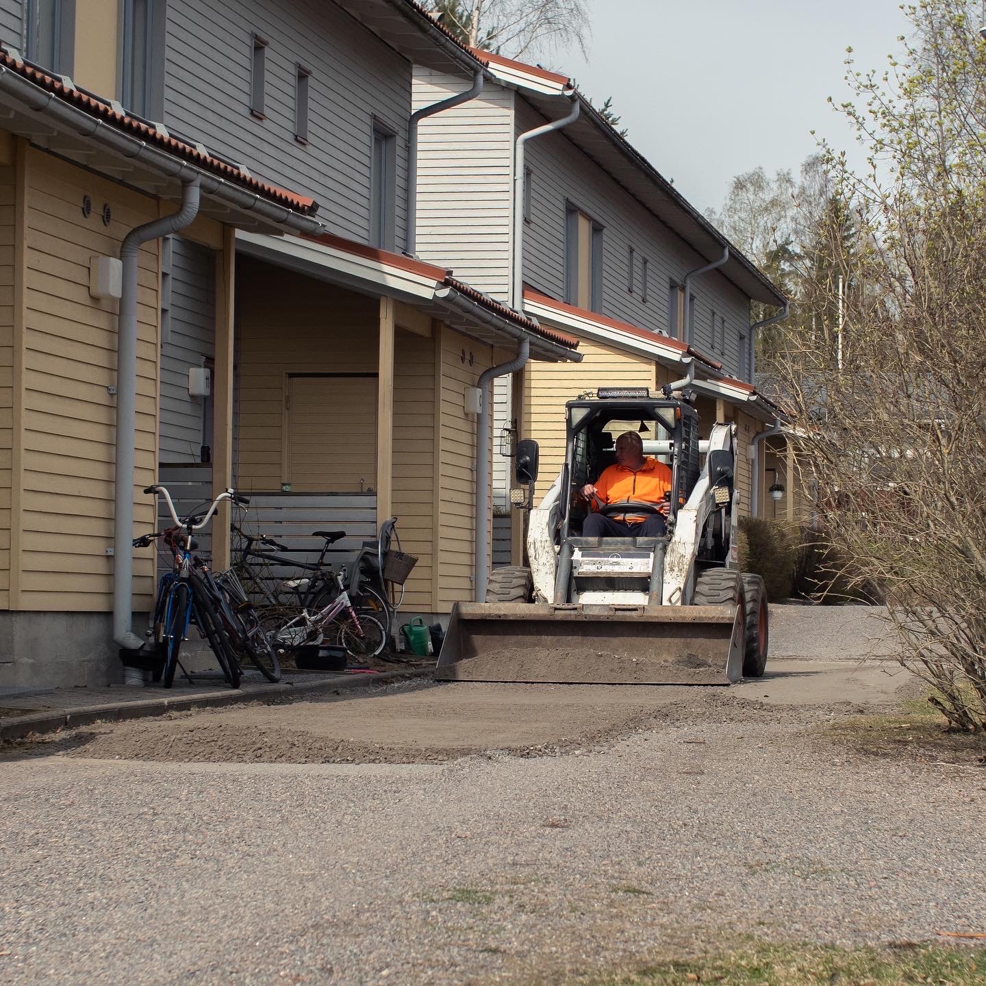 Pienkuormaaja taloyhtiön pihan maanrakennustyössä