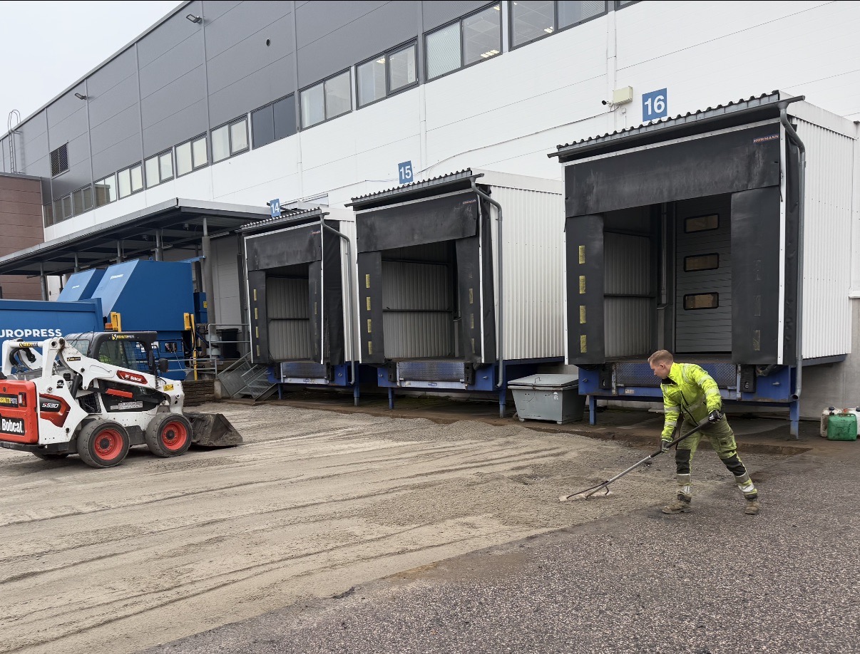 Bobcat ja Asfalttikaistan työntekijä Transmeri Logisticsin lastauslaitureiden edustalla